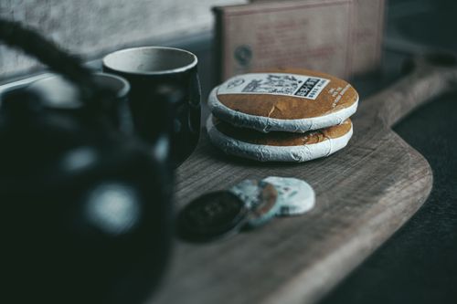 Free An evocative still life featuring puerh tea cakes and a ceramic teapot for a traditional tea experience. Stock Photo