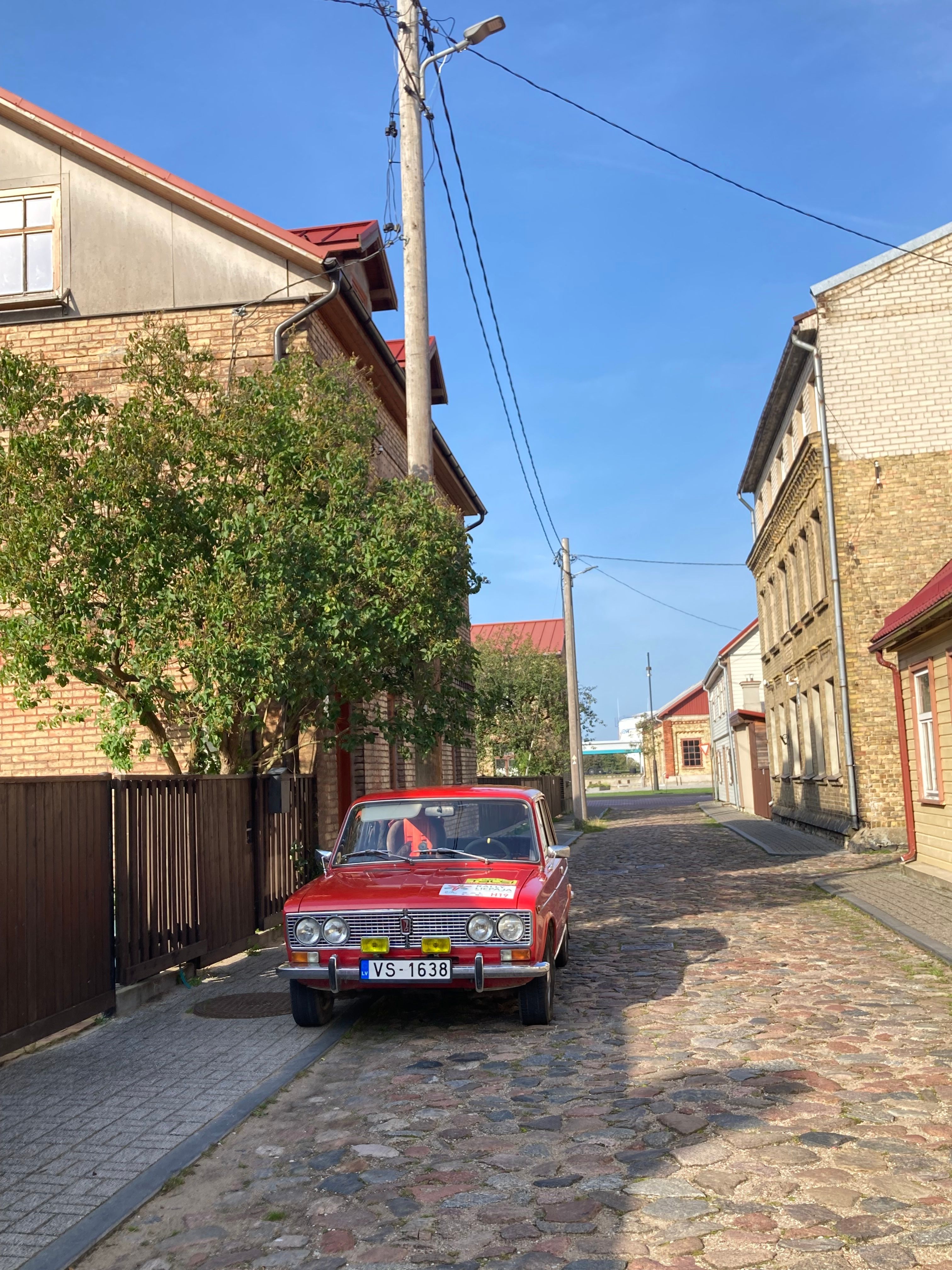 Classic Red Car on a Sunny Cobblestone Street · Free Stock Photo