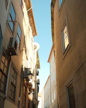 Charming narrow alley with historic buildings in Porto, Portugal showcasing a sunny perspective.