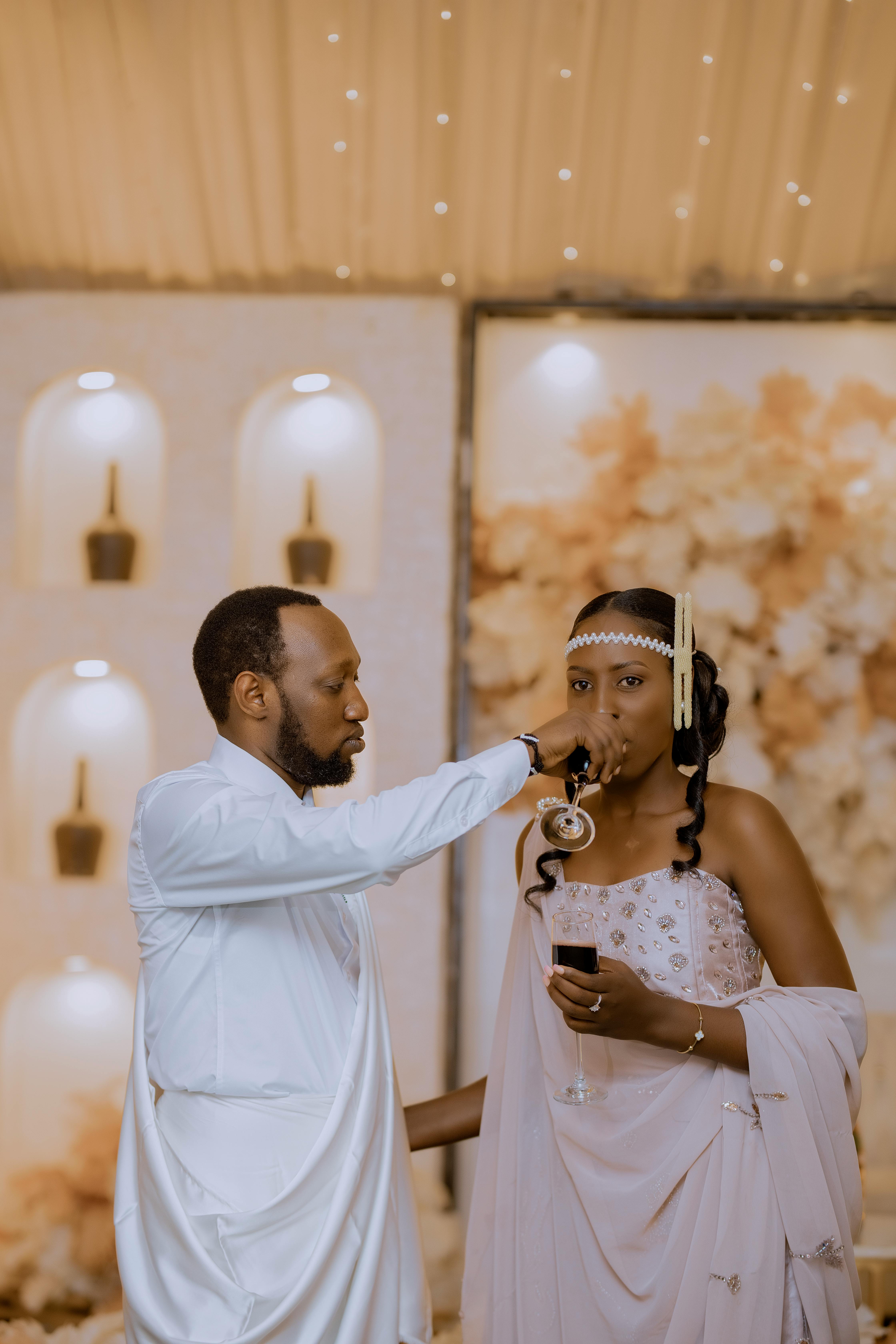 Gratis Una pareja con atuendo tradicional celebrando su boda en Kigali, Ruanda, con elegancia y gracia. Foto de stock