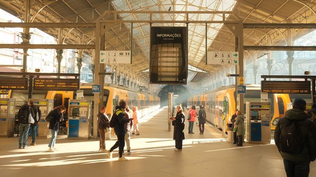 Commuters in the bright interior of São Bento Train Station, Porto, Portugal.