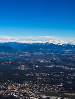 Stunning aerial view showcasing Lecco and the snow-capped Alps under a clear blue sky.
