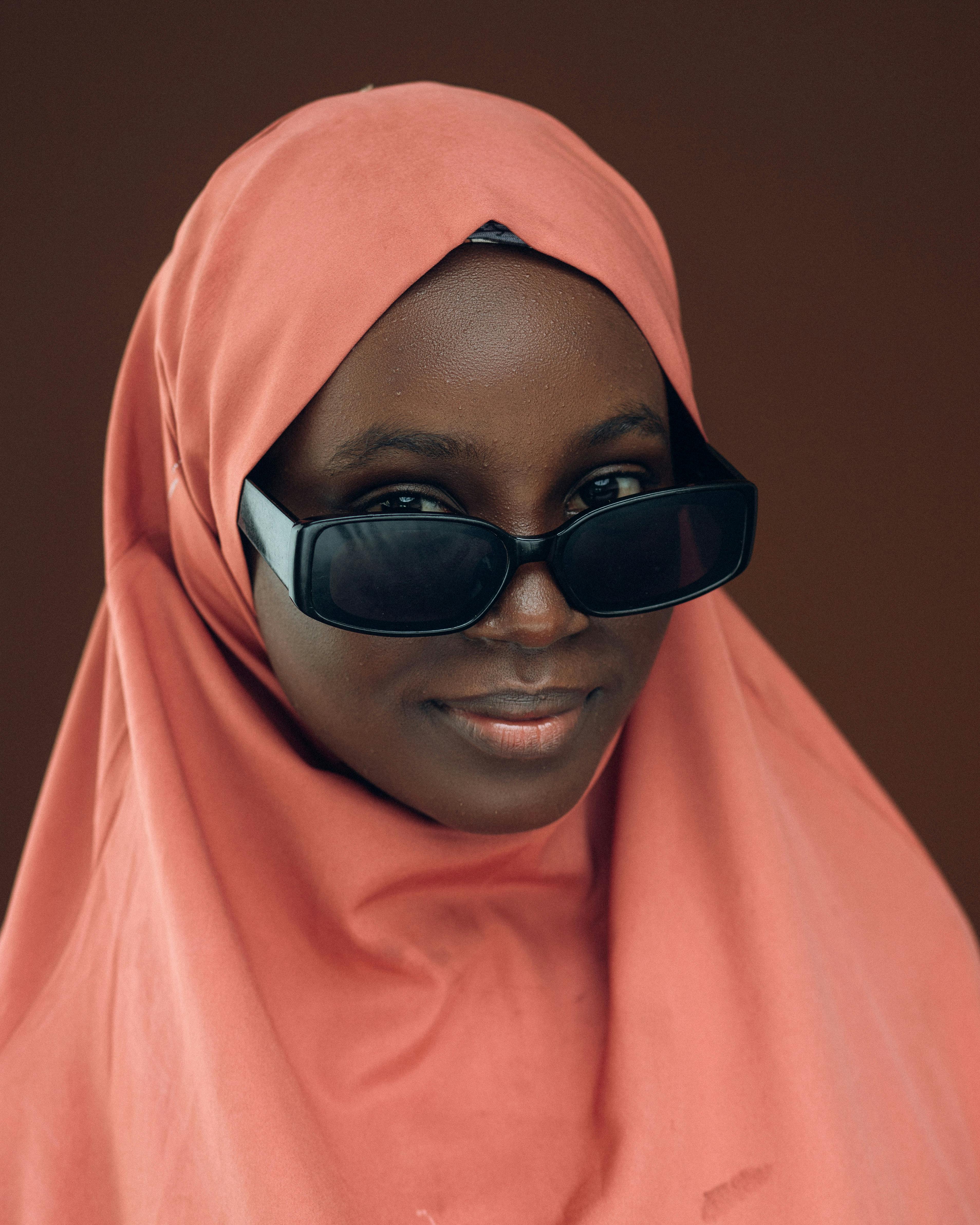 Gratis Retrato de una mujer que viste un hijab y gafas de sol, irradiando confianza y estilo. Foto de stock