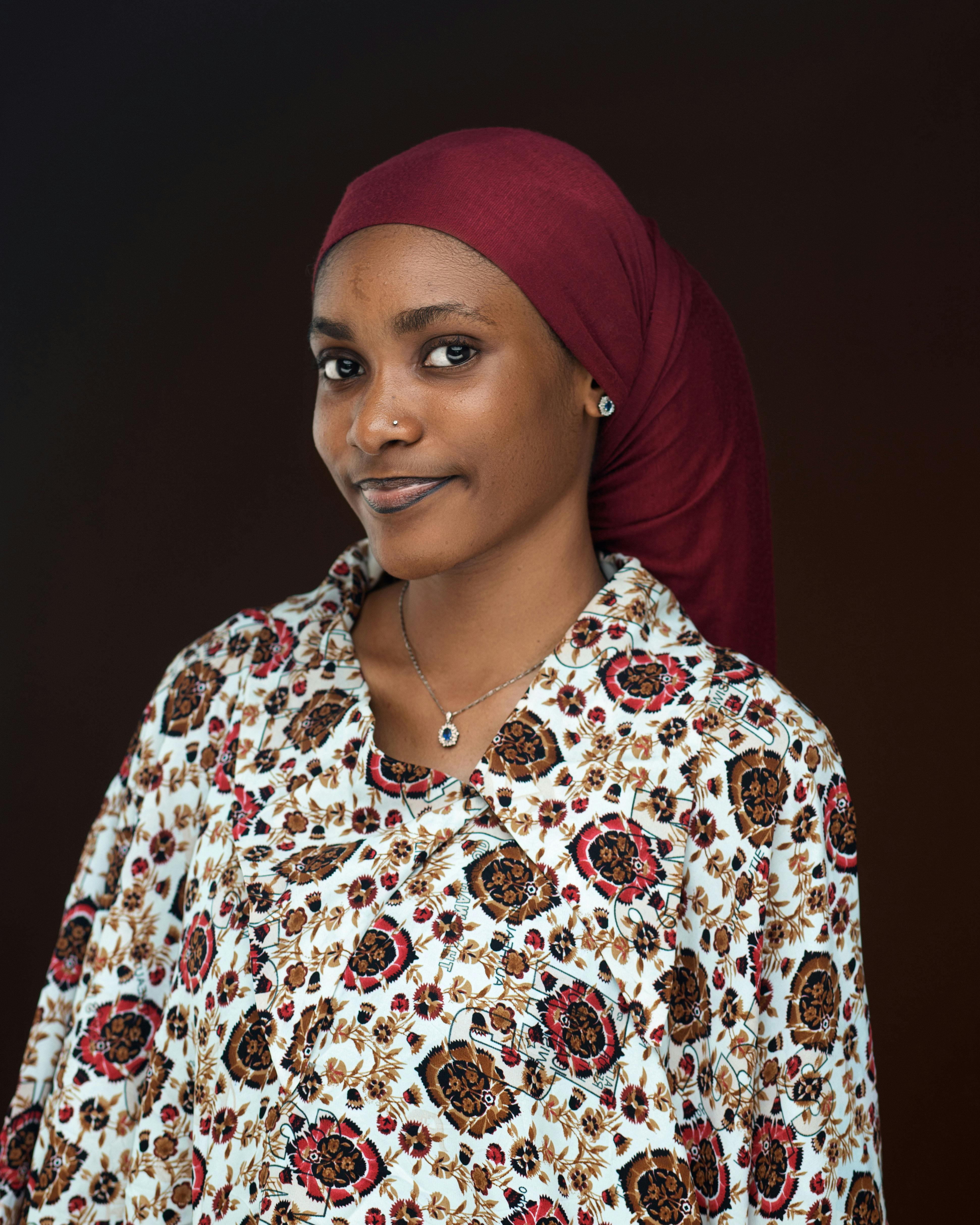 Elegant portrait of a smiling woman wearing a patterned blouse and maroon scarf, perfect for lifestyle or fashion themes.