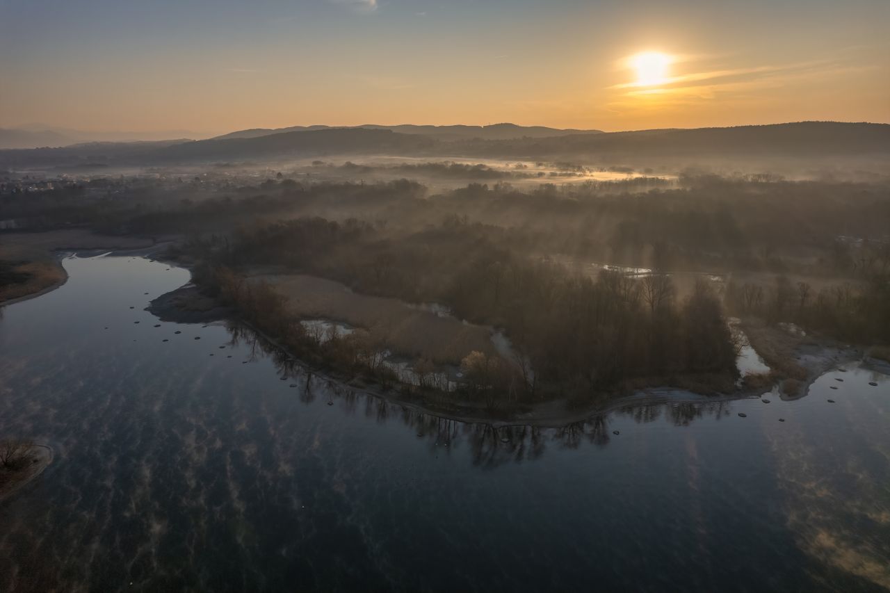 a breathtaking aerial view of a tranquil lake and misty landscape at s