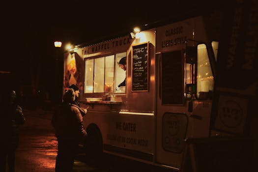 Food truck serving waffles at night, illuminated by streetlight.