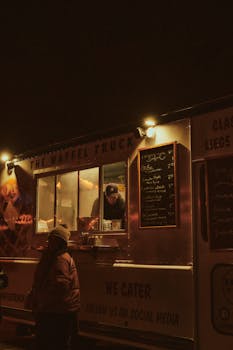 A cozy waffle food truck serving customers at night under warm lights.