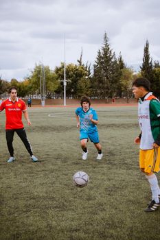 Three young male athletes participate in a soccer training session on a field in Puebla, Mexico.