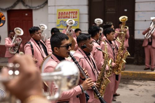 Free Brass band in pink suits performing on a lively city street parade. Stock Photo