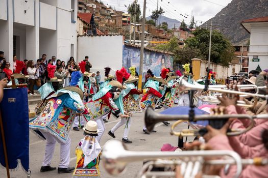Colorful festival parade with traditional costumes and musicians in a lively street setting.
