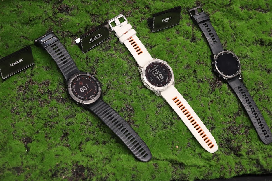 Apple Watch Ultra 3 vs Garmin Fenix 8: GPS & Battery Test for Ultramarathon (2024) Three outdoor watches displayed on a textured green surface, featuring Fenix model options.