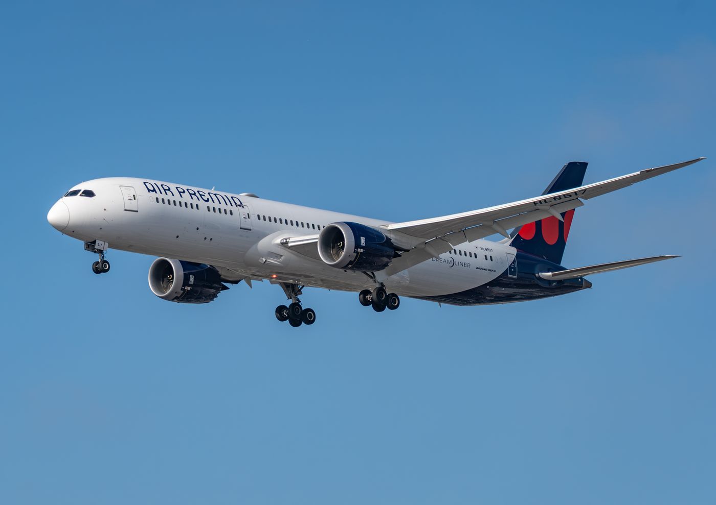 An Air Premia Boeing 787-9 Dreamliner on approach to Los Angeles International Airport against a clear blue sky