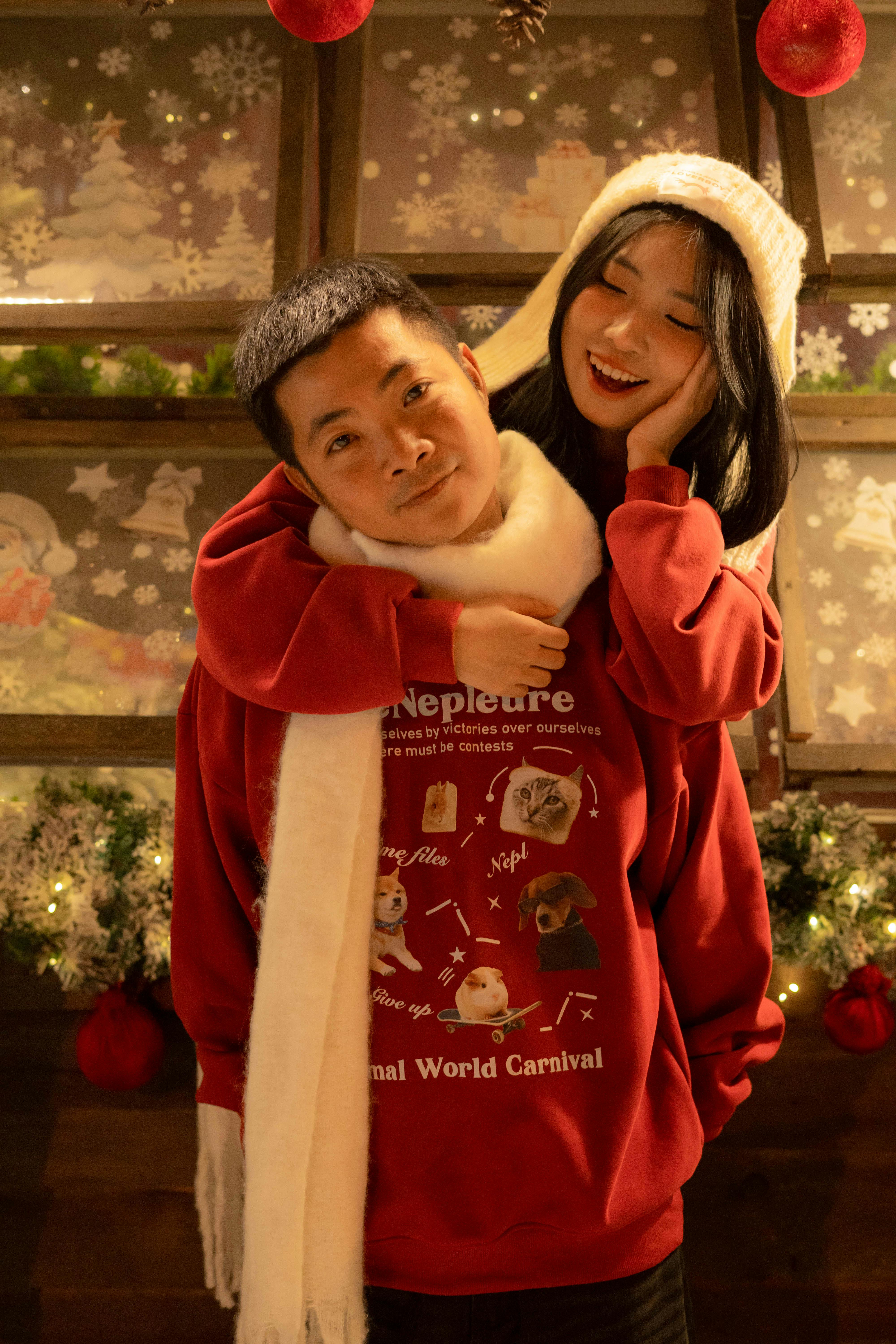 De franc Una parella feliç amb vestits nadalencs acollidors gaudint de les vacances festives a l'interior. Foto d'estoc