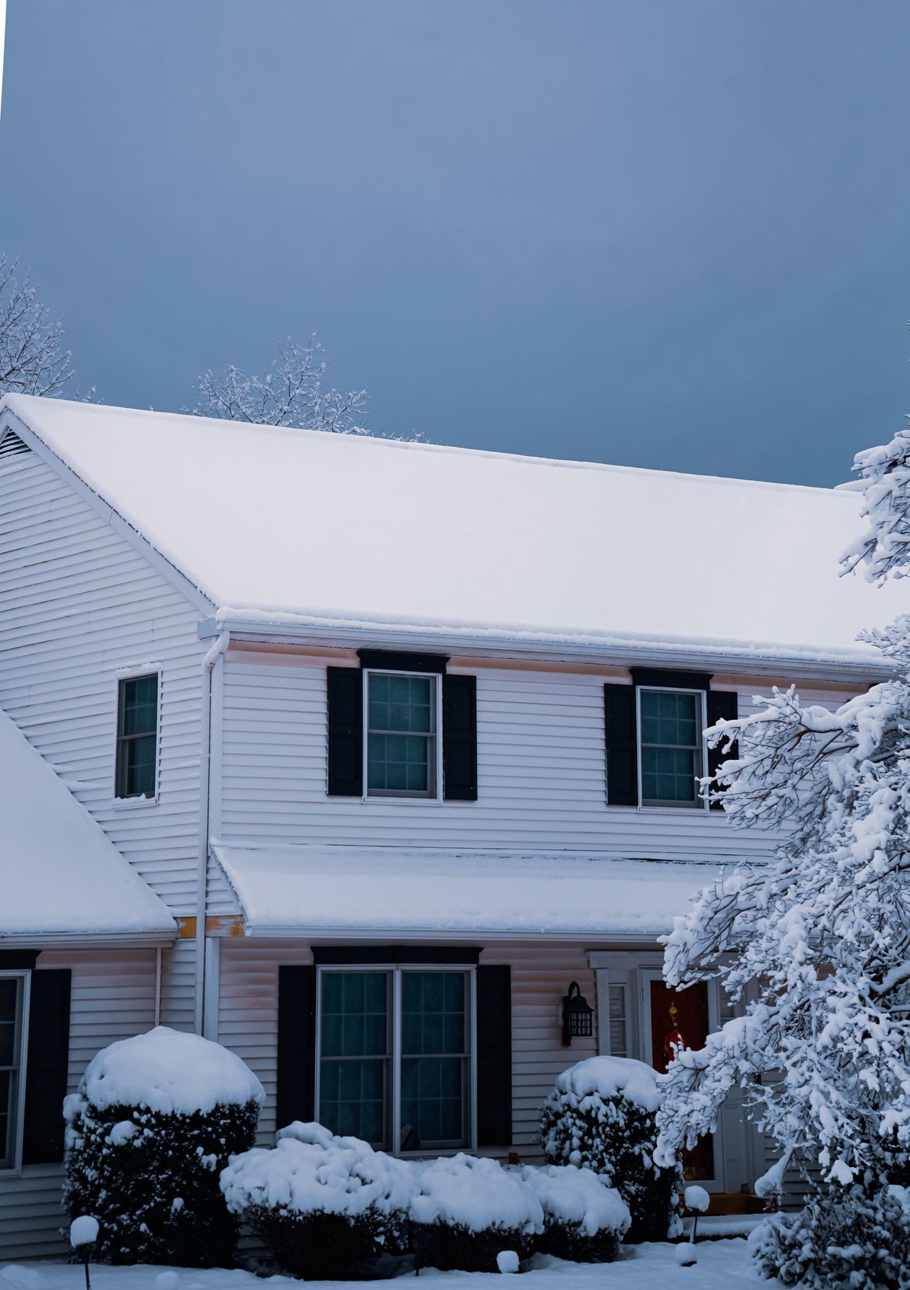 Classic two-story suburban home with dark shutters blanketed in fresh snow, Huntington Commons, Naperville IL