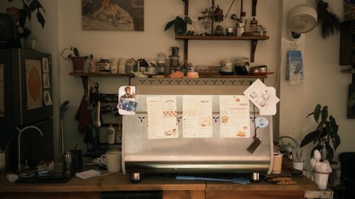 Free Vintage-style coffee bar with warm decor, menus, and memorabilia. Stock Photo