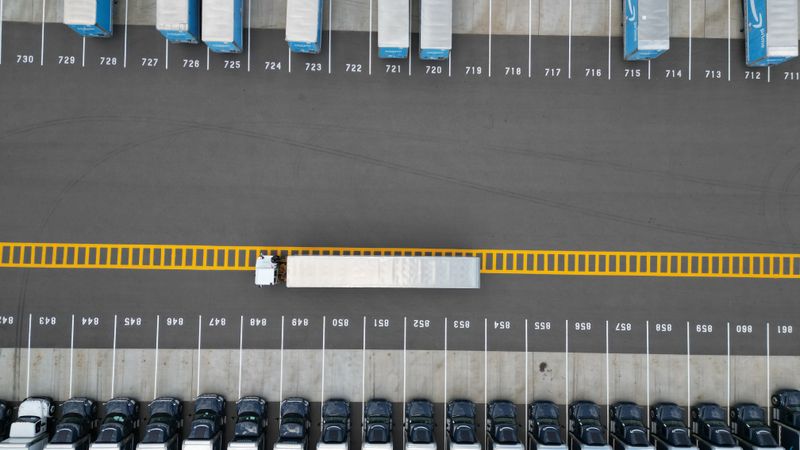 Top-down aerial image of truck trailers parked in a lot with distinct yellow markings.