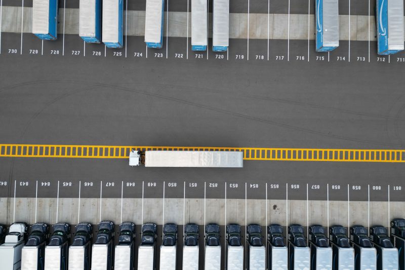 Top-down aerial image of truck trailers parked in a lot with distinct yellow markings.