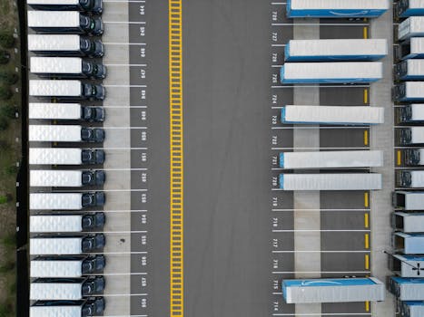 Top-down view of lined-up trucks at a logistics parking lot, showing organized transportation hub.