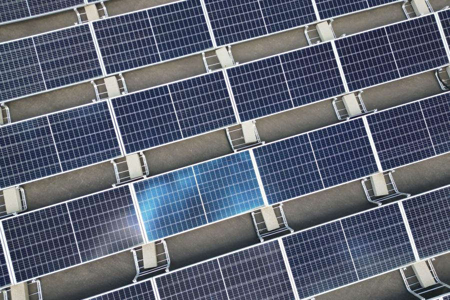 Aerial view of a large array of solar panels on a rooftop, utilizing renewable energy.