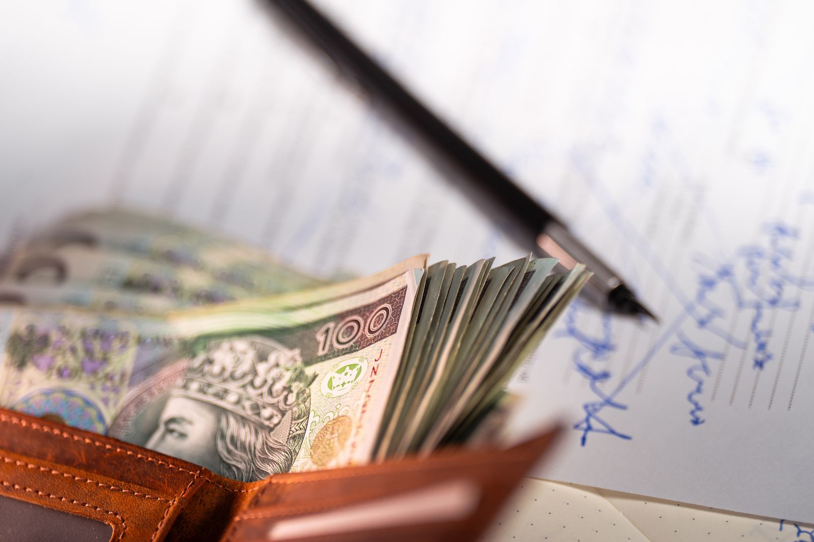 Polskie złote, dokument finansowy i długopis przed zawarciem umowy pożyczki