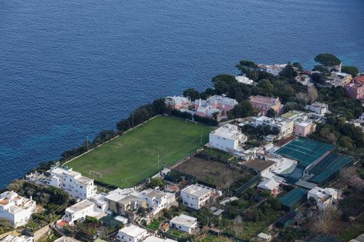 Stunning aerial shot of Capri's coastal charm with villas and lush greenery.