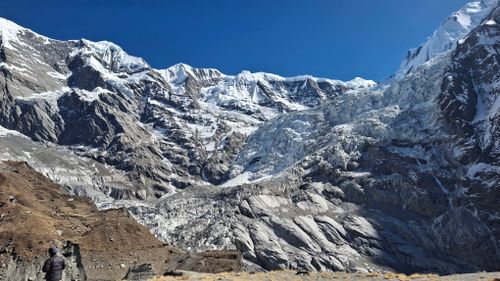 Free A breathtaking view of the Himalayas with a person gazing at the snowy peaks. Stock Photo