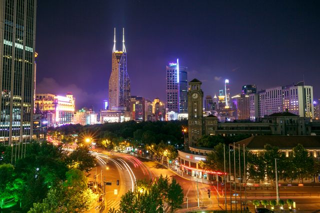 A mesmerizing cityscape at night featuring illuminated skyscrapers and busy street light trails.