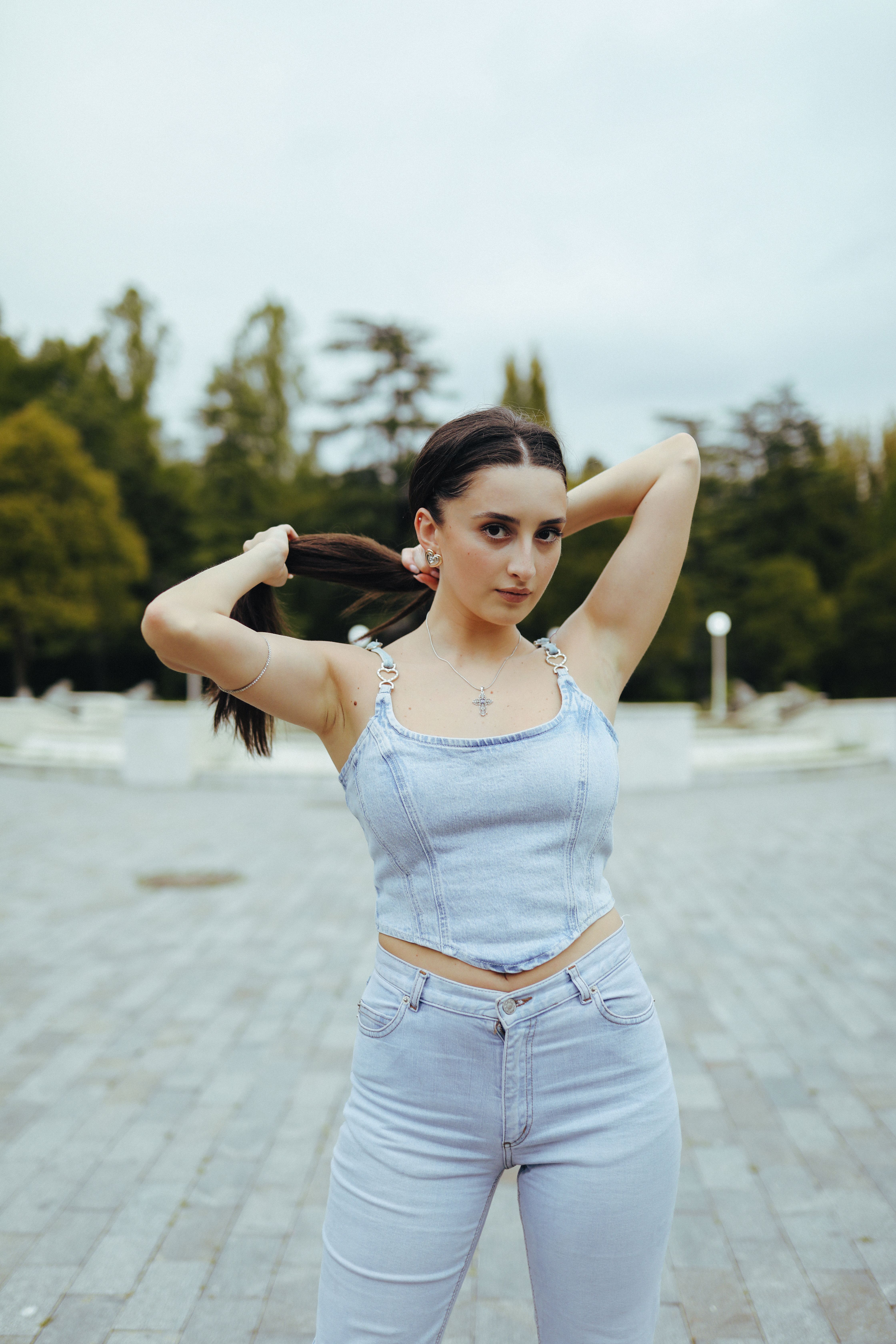 Stylish young woman in a denim outfit posing outdoors in Tbilisi, Georgia.