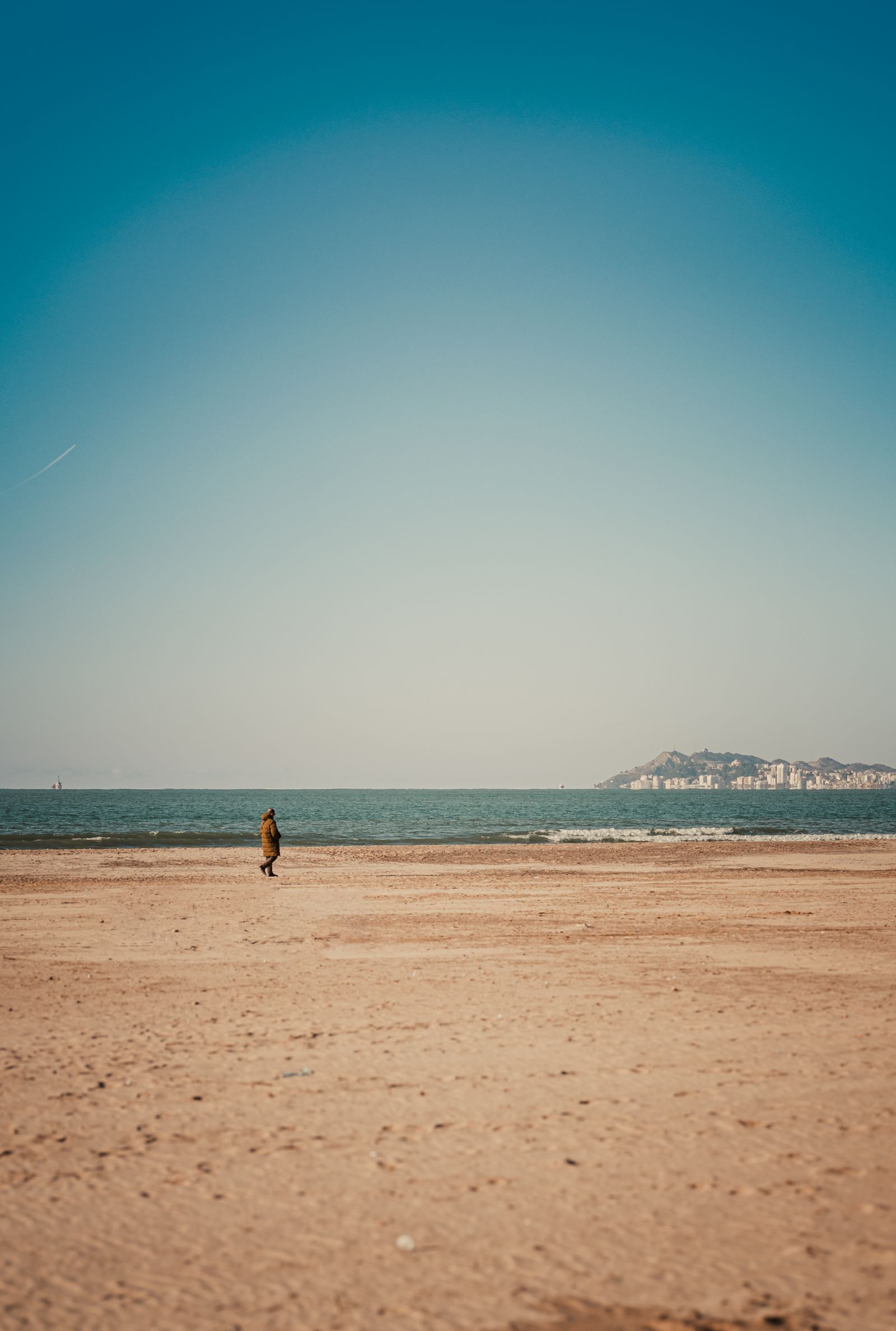 Quiet beach walk under clear skies in Qerret, Tirana County, Albania