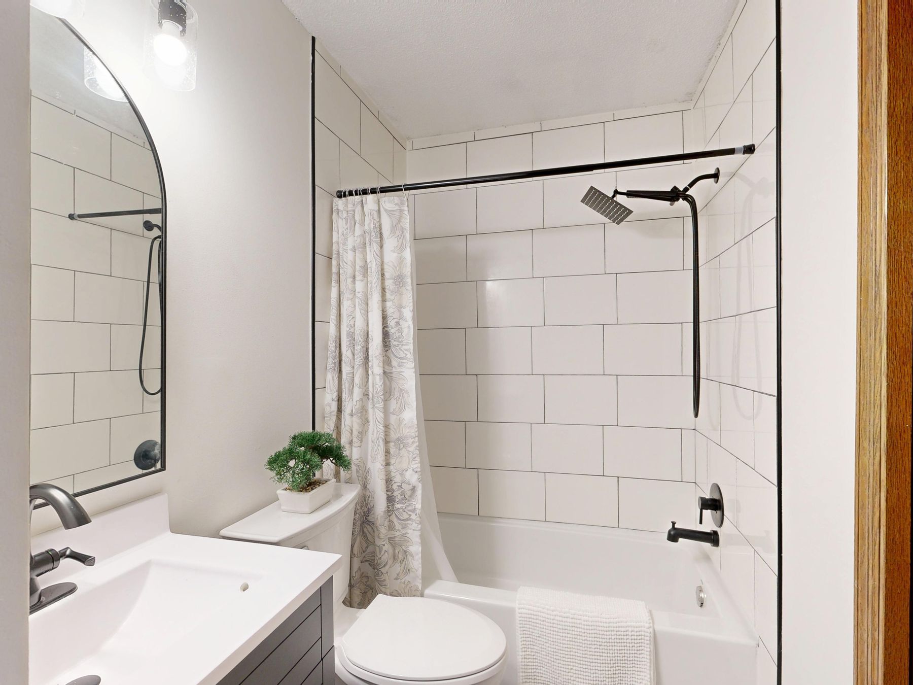 Light tiled bathroom with black fixtures and clean modern lines