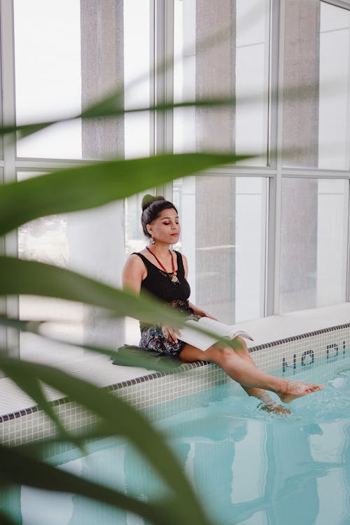 Frau Sitzt Am Pool