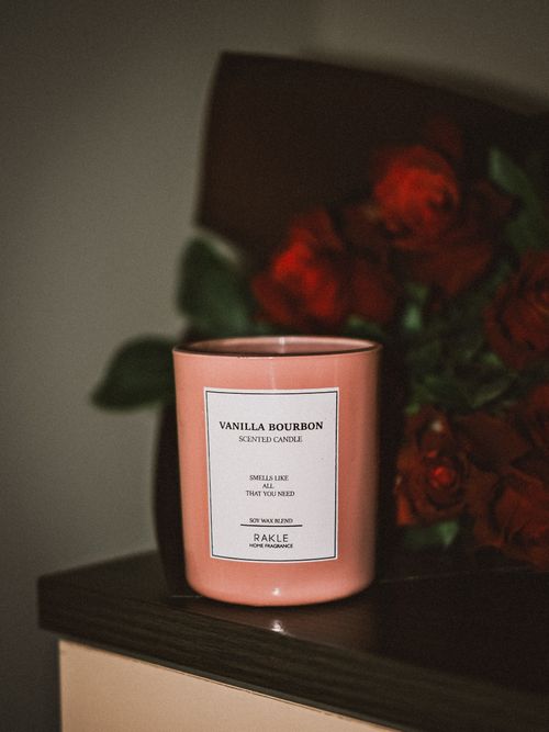Free A cozy scene with a vanilla bourbon scented candle and red roses indoors. Stock Photo