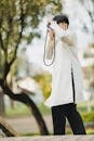 Young Man in Traditional Outfit Taking Photos Outdoors