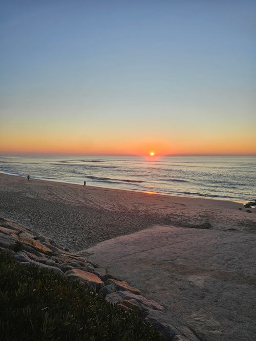 Free Beautiful sunset on a tranquil beach with gentle waves, perfect for a peaceful retreat. Stock Photo