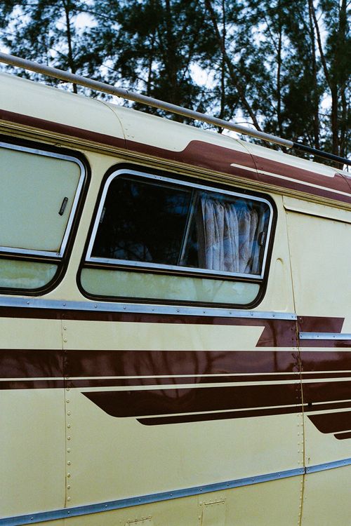 Free Detailed shot of a vintage camper van window, highlighting the retro design and color scheme. Stock Photo