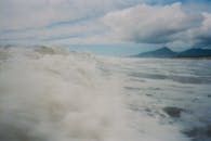 在遥远的岛屿附近，海浪在多云和暴风雨的天空下撞击，景色迷人