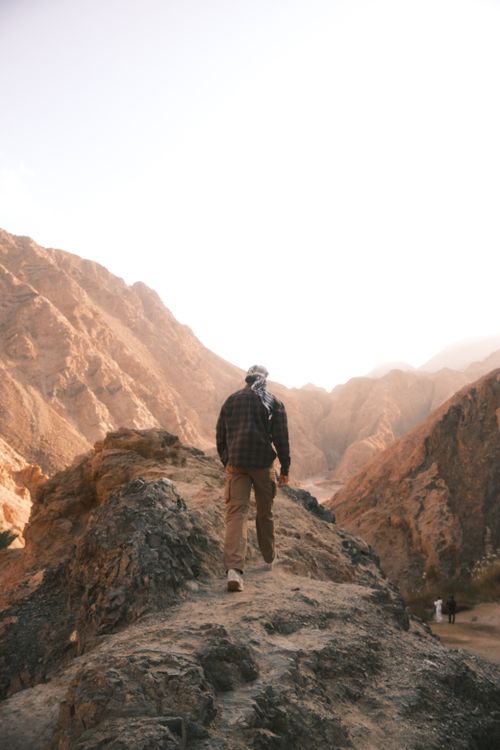 Free A solitary man hikes a rocky path surrounded by mountain peaks in Dahab, Egypt. Stock Photo