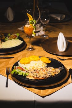 Delicious gourmet dish with rice, vegetables, and fish on an elegant dining table.