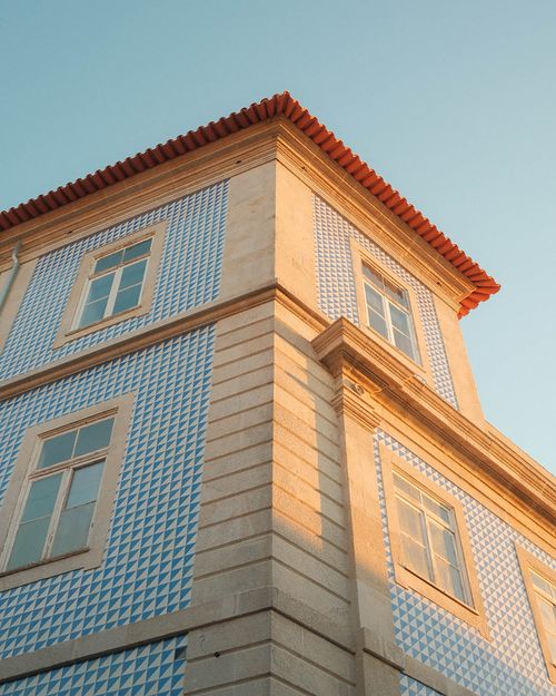 Free Elegant facade of a Portuguese building with blue azulejos under warm sunset light. Stock Photo