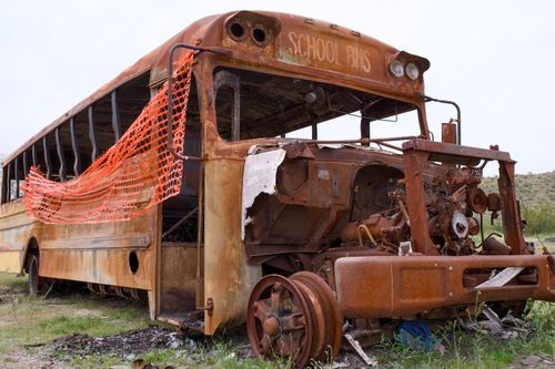 Free Decaying and rusted school bus abandoned in Arizona desert landscape. Stock Photo