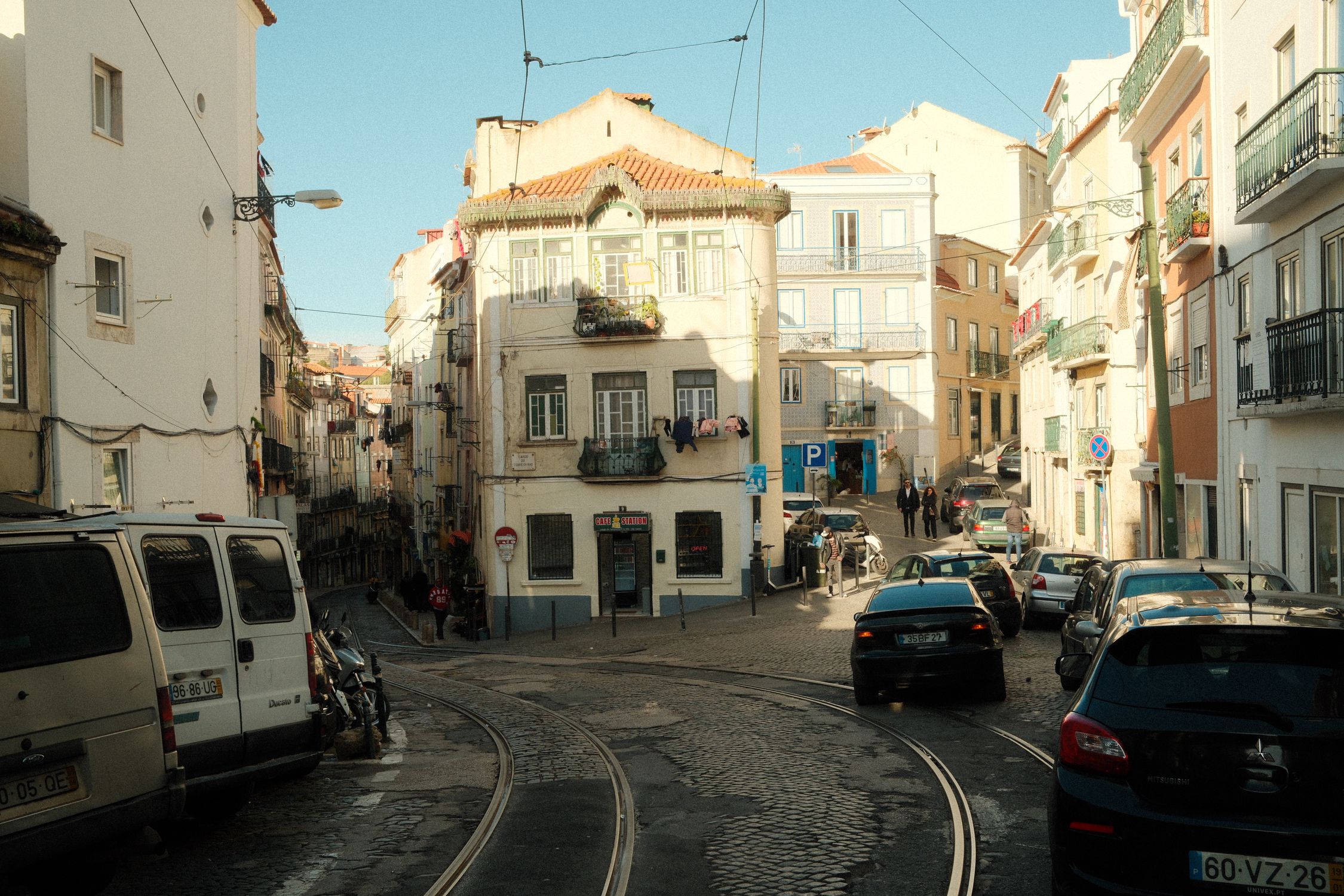 A lively street scene in Lisbon, Portugal featuring cobblestones, buildings, trams, and cars, capturing the essence of the city