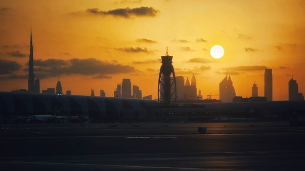 Dramatic view of Dubai skyline featuring Burj Khalifa at sunset.
