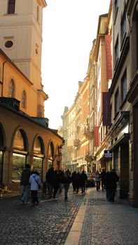 A charming cobblestone street in Prague lit warmly at dusk, capturing the city's historic architecture and vibrant ambiance.