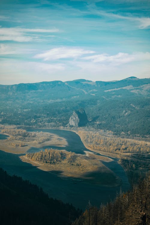 Mountain ridge and flowing river in haze · Free Stock Photo