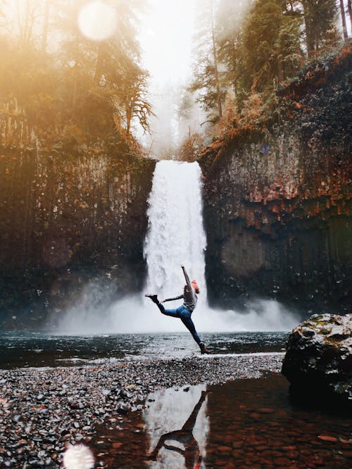 Person Posing Across Waterfall