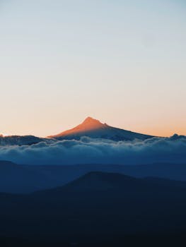 日出时分，山峰的壮丽景色映衬在戏剧性的云层天空下
