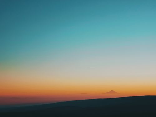 Free Amazing view of flat terrain with mountain peak on horizon under bright sunset sky in evening Stock Photo