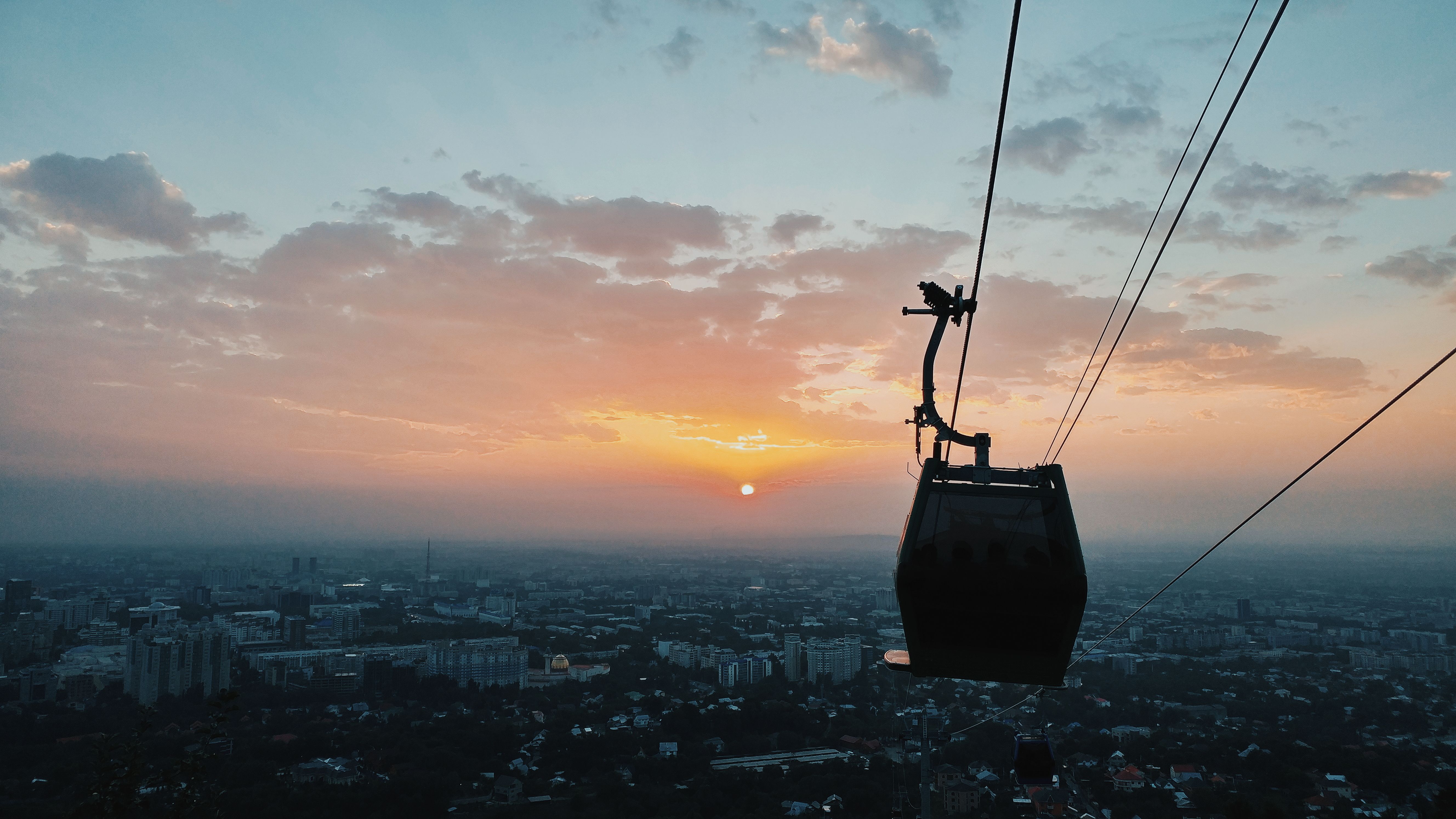 Ropeway and cloudy sky above city architecture · Free Stock Photo