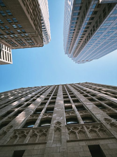 Free Low angle view of skyscrapers under clear blue sky emphasizing urban architecture. Stock Photo