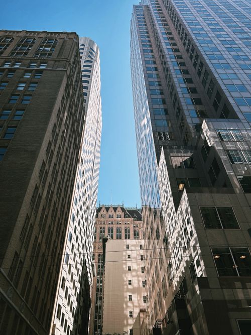 Free Sunlit view of towering skyscrapers creating an urban canyon effect. Stock Photo